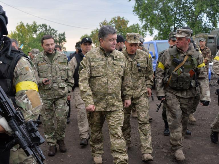 Der ukrainische Präsident Petro Poroschenko begleitet mit einer Militäruniform bekleidet ukrainische Soldaten während eines Besuches im Armee-Hauptquartier nahe der Stadt Izyum am 08.07.2014.