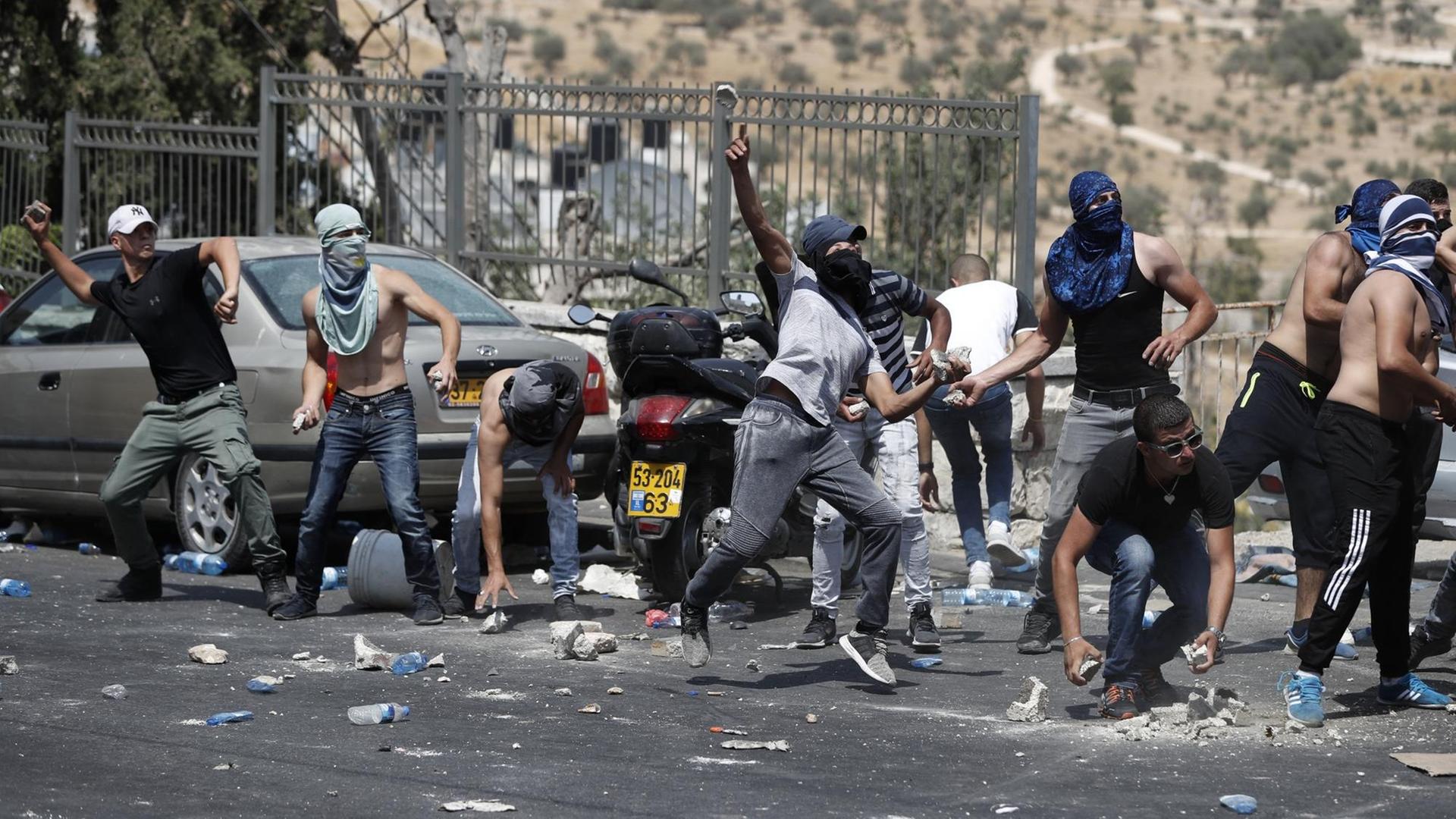Palästinensische Demonstranten werfen Steine während eines Zusammenstoßes mit israelischen Sicherheitskräften nahe der Altstadt von Jerusalem.