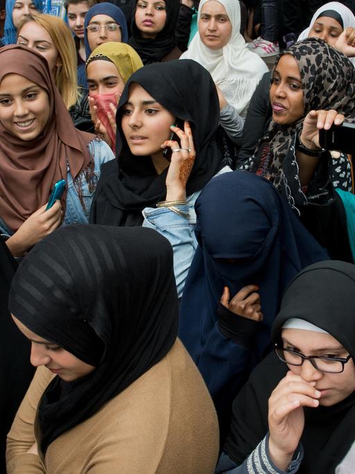 Junge Frauen verfolgen eine Kundgebung des radikalen Salafistenpredigers Pierre Vogel in Offenbach am Main.