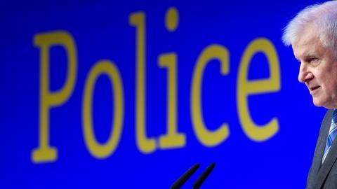 Innenminister Seehofer spricht in ein Mikrofon. An der Wand hinter ihm steht das englische Wort "Police"