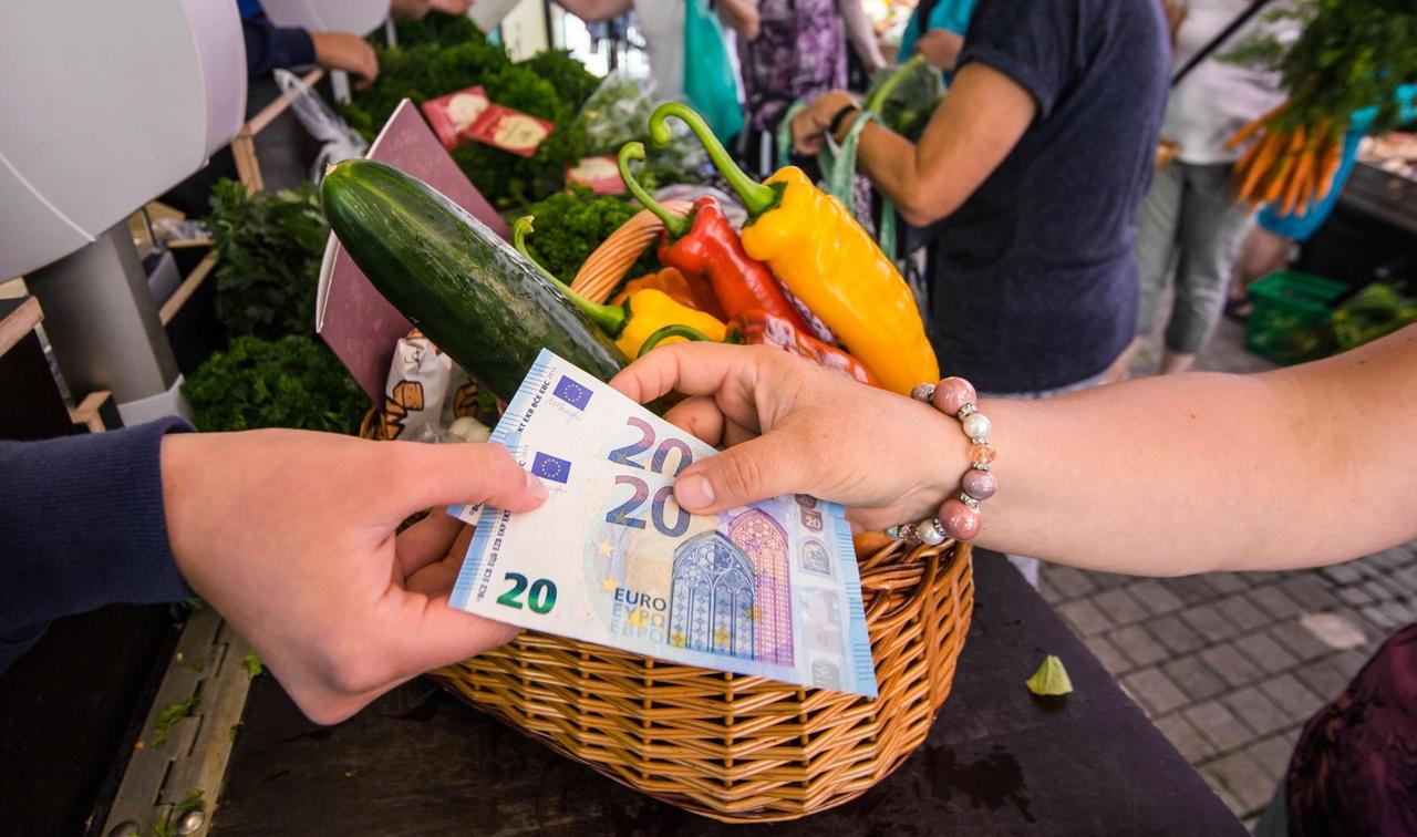 Bezahlung mit Bargeld auf einem Wochenmarkt