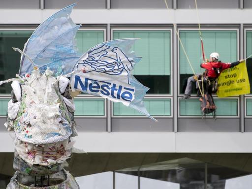 Greenpeace-Aktivisten bringen dem Lebensmittel- und Getränkegiganten Nestlé ein riesiges Monster aus Plastik zurück, das Greenpeace auf See und an den Stränden vor dem Hauptsitz von Nestle in Vevey, Schweiz geborgen hat.