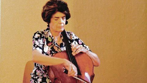Die Cellistin Angelica May auf einem künstlerisch bearbeiteten Farbfoto, Violoncello spielend