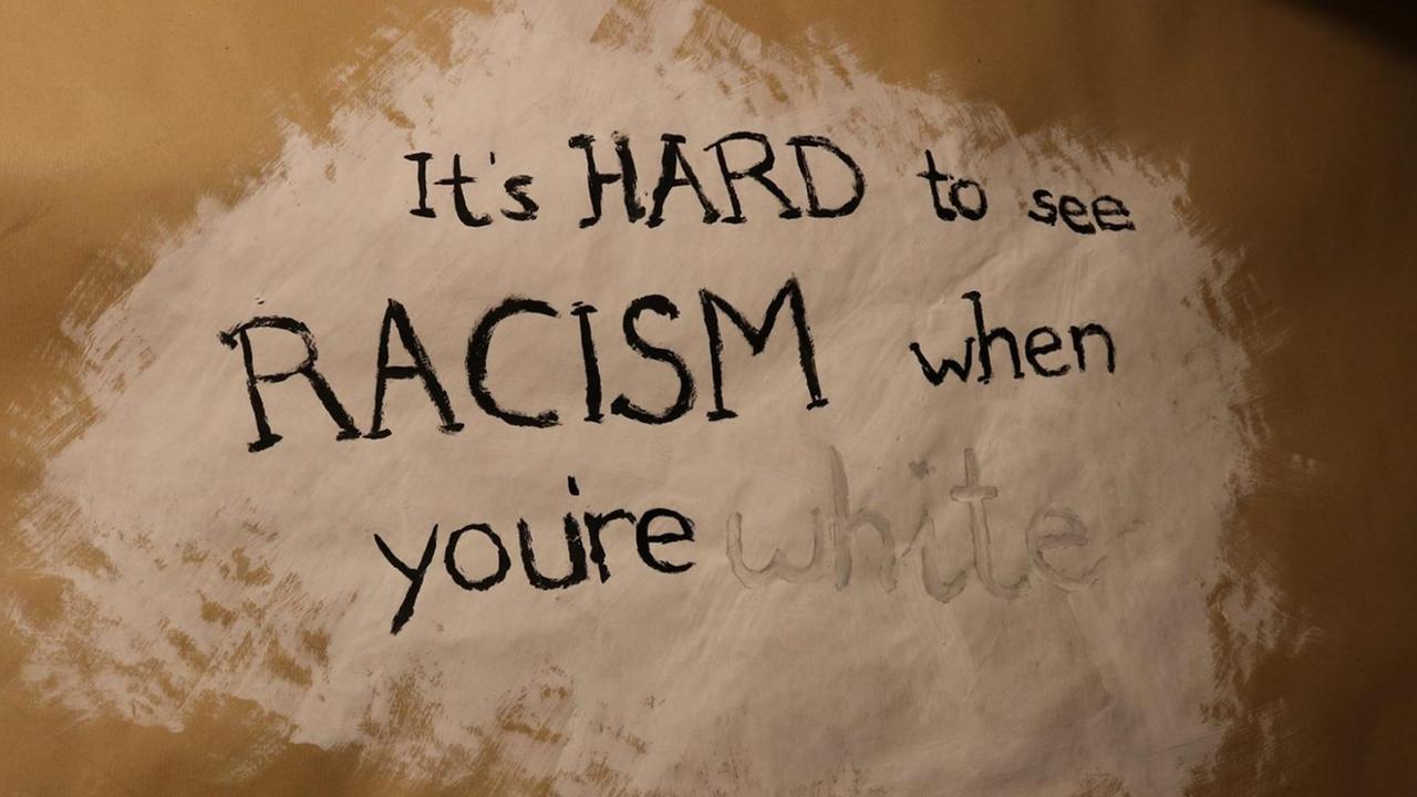Scharze Schrift auf weißen Untergrund: Dort steht in englischer Sprache. Es schwer Rassismus zu sehen, wenn man weiß ist.
