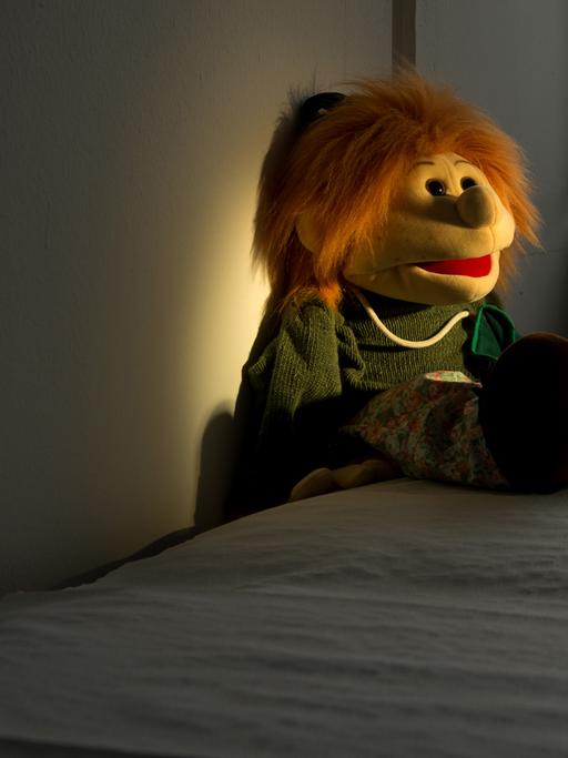Eine Handpuppe auf einer Liege in einem Untersuchungsraum in der Kinderschutzambulanz
