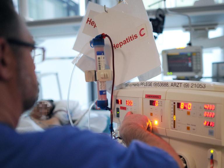 Ein Intensivpfleger kümmert sich in Hamburg auf der Intensivstation des Universitätsklinikum Hamburg-Eppendorf (UKE) um einen Patienten mit Hepatitis C.