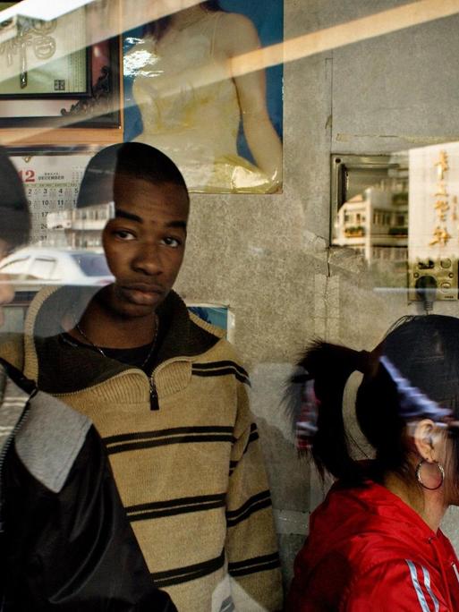 Symbolbild, auf dem ein afrikanischer Händler in Guangzhou in ein Fotogeschäft geht.
