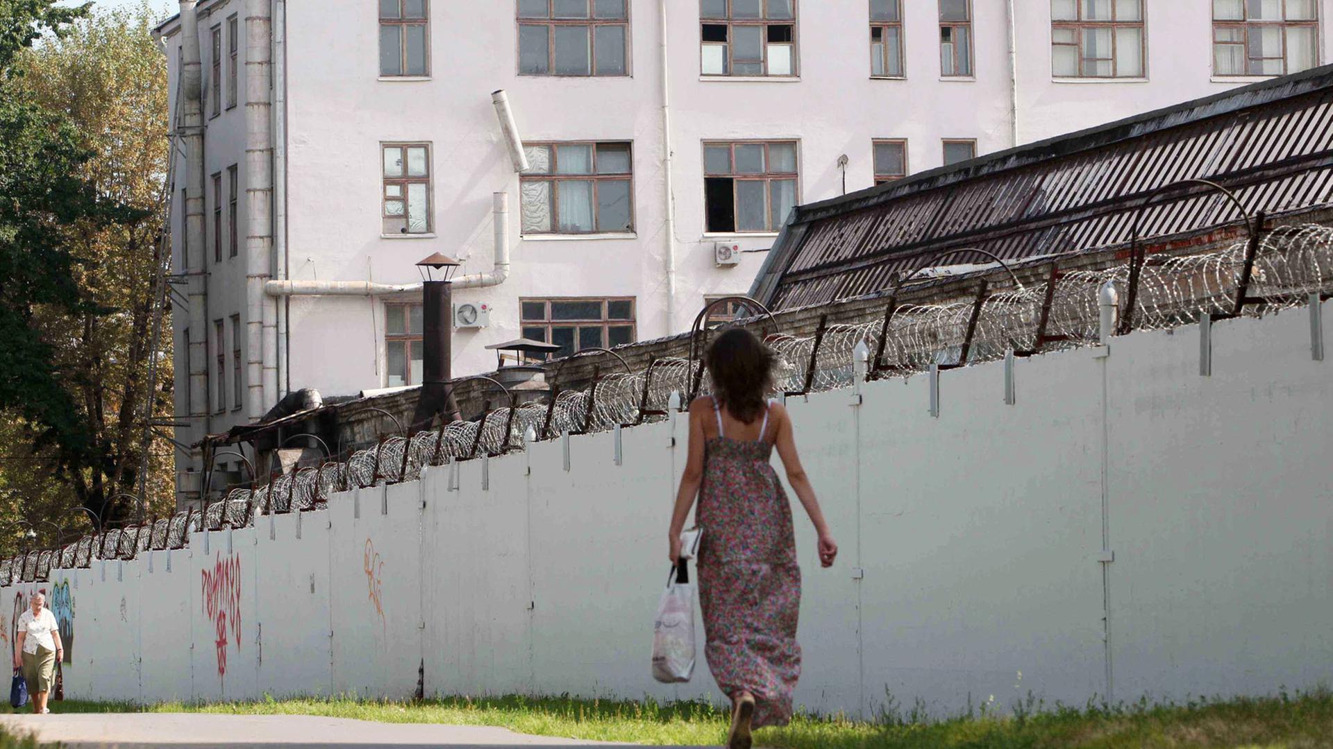 Menschen laufen an den mit Stacheldraht bedeckten Mauern des russischen Untersuchungsgefängnis Lefortovo in Moskau vorbei. Menschen laufen an den mit Stacheldraht bedeckten Mauern des russischen Untersuchungsgefängnis Lefortovo in Moskau vorbei.