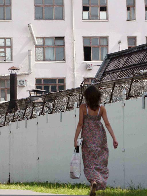 Menschen laufen an den mit Stacheldraht bedeckten Mauern des russischen Untersuchungsgefängnis Lefortovo in Moskau vorbei.