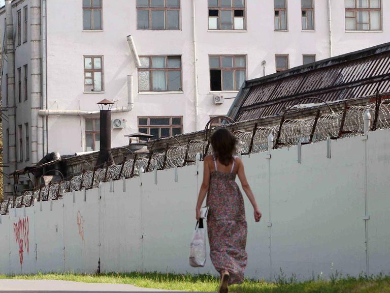 Menschen laufen an den mit Stacheldraht bedeckten Mauern des russischen Untersuchungsgefängnis Lefortovo in Moskau vorbei.