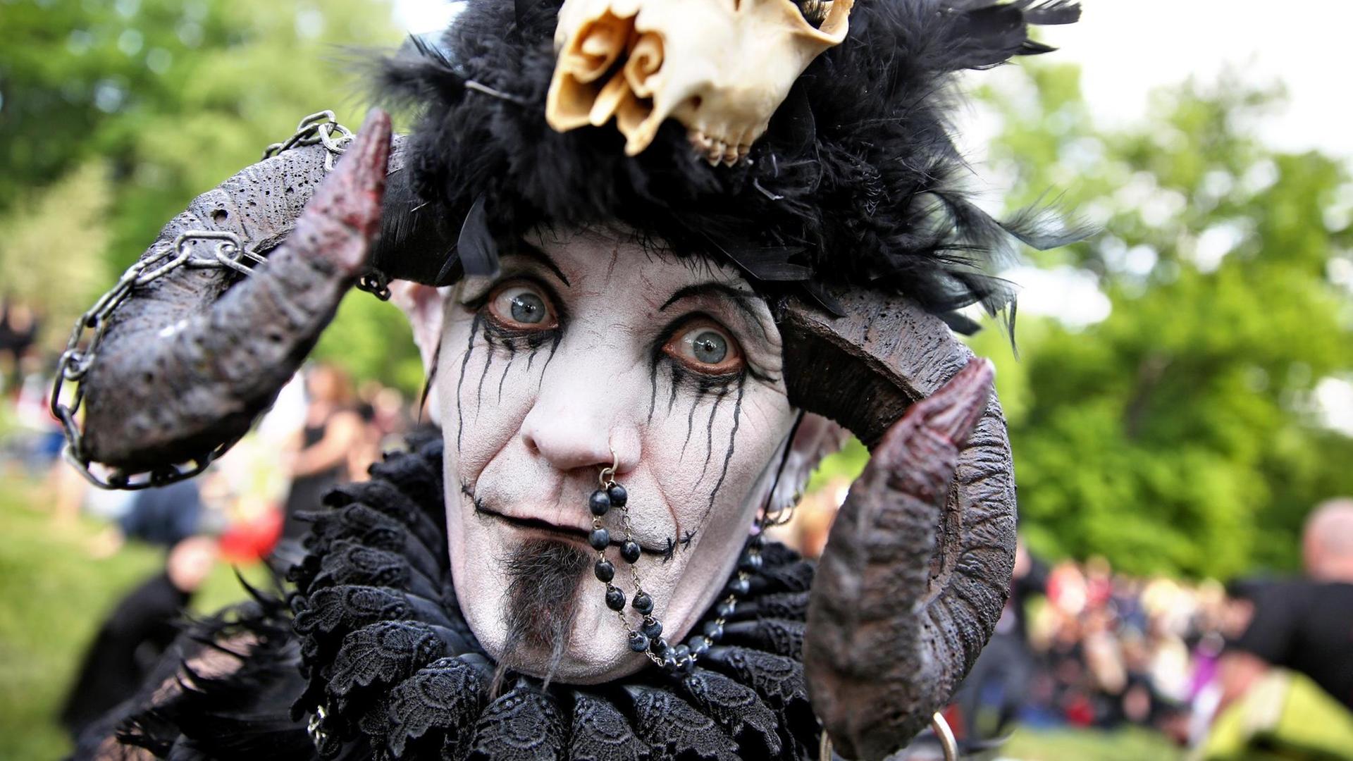 Teilnehmer des Wave-Gotik-Treffens in Leipzig 2015 mit weiß-schwarz geschminktem Gesicht und Hörnern auf dem Kopf.