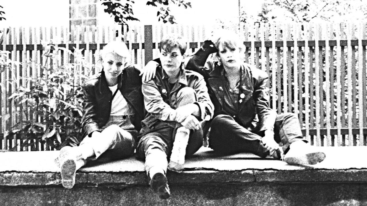 Drei Mitglieder der Düsseldorfer Punkband Östro 430 sitzen Anfang der 80er Jahre auf einer Mauer.