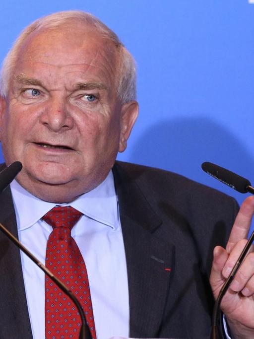 Daul spricht vor einer blauen Wand mit dem EPP-Schriftzug in zwei Mikrofone und hebt beide Zeigefiner in Schulterhöhe.