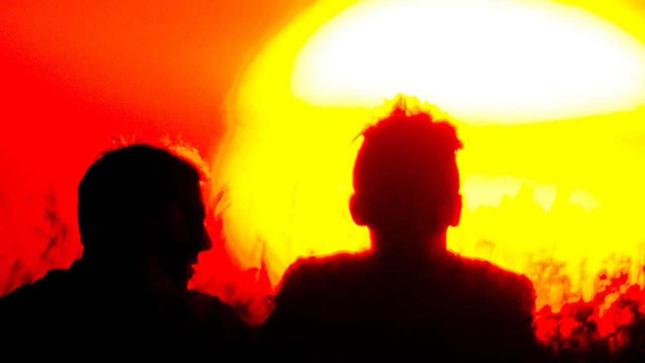 Drei Männer sitzen am 17.07.2014 in Berlin bei Sonnenuntergang auf dem Teufelsberg.