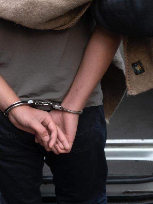 Polizisten führen einen verdächtigen Mann nach einer Razzia gegen kriminelle Mitglieder arabischer Großfamilien ab.