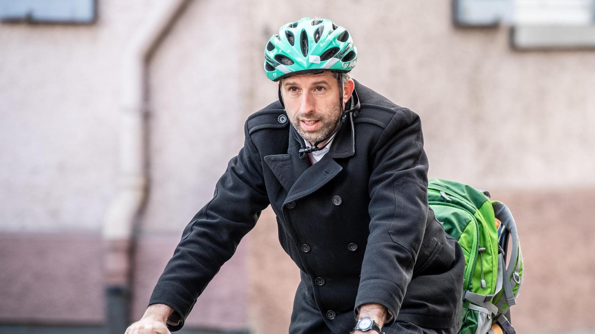 Boris Palmer, Oberbürgermeister von Tübingen (Bündnis 90/Die Grünen), kommt mit einem grünen Helm auf dem Kopf mit dem Fahrrad zu einer Demonstration vor der Landesversorgungsanstalt der Ärzte.