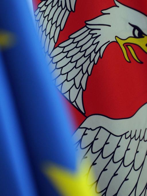 Die serbische Flagge neben der Flagge der EU.