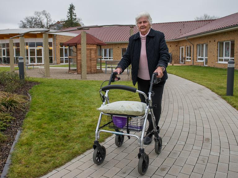 Eine 81-jährige Demenz-Patientin geht im Garten der Wohnanlage Tönebön am See in Hameln spazieren.