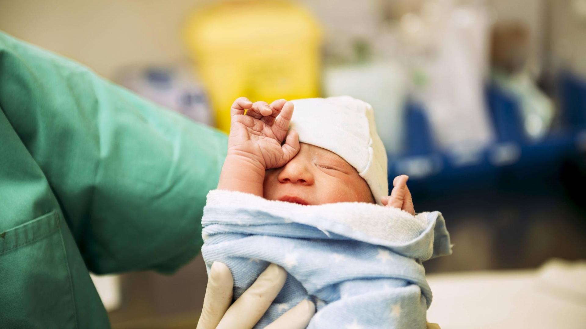 Ein neugeborenes Baby, in eine Decke gewickelt.(Symbolfoto)