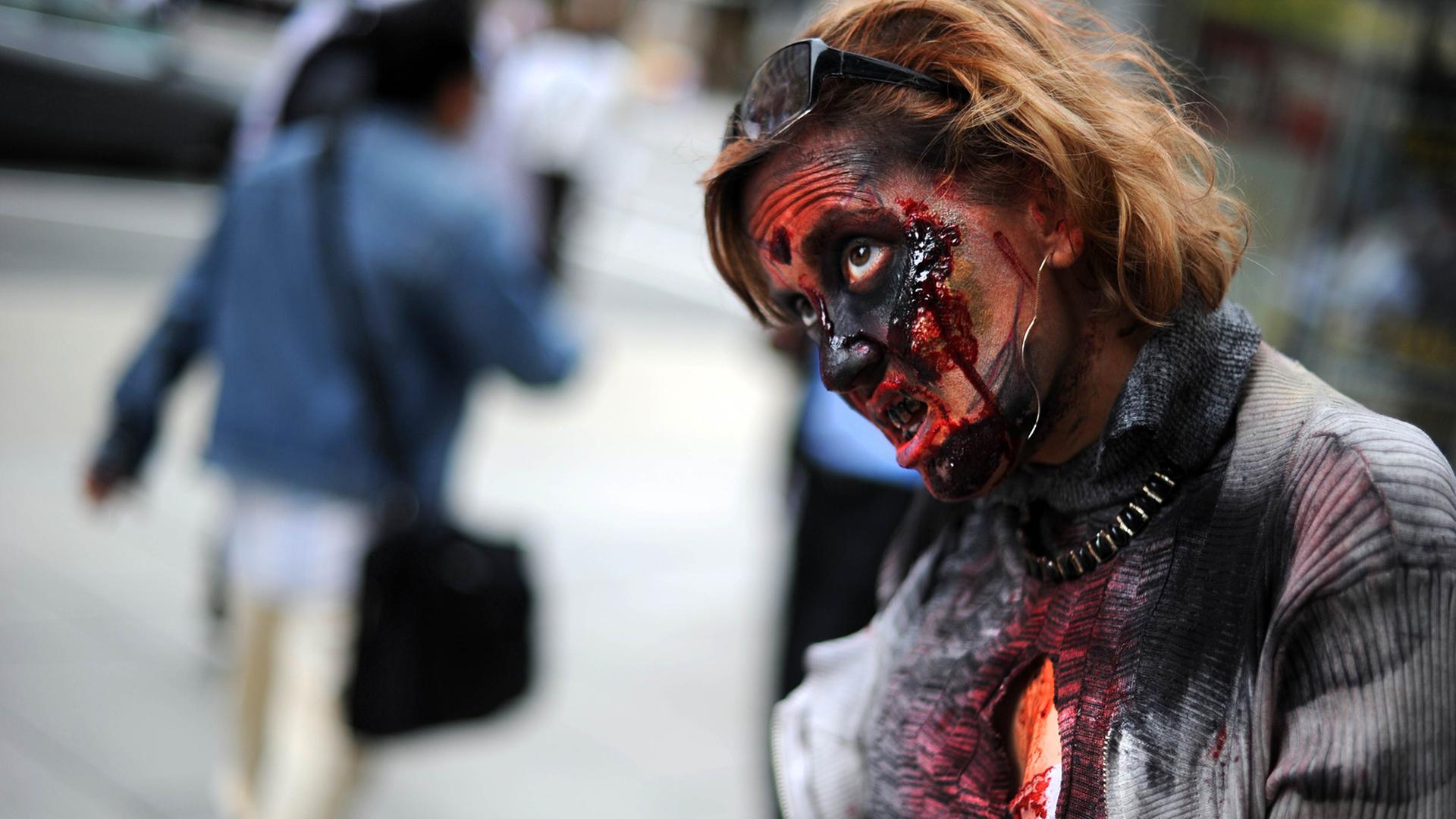 Eine Frau hat sich als Zombie verkleidet.