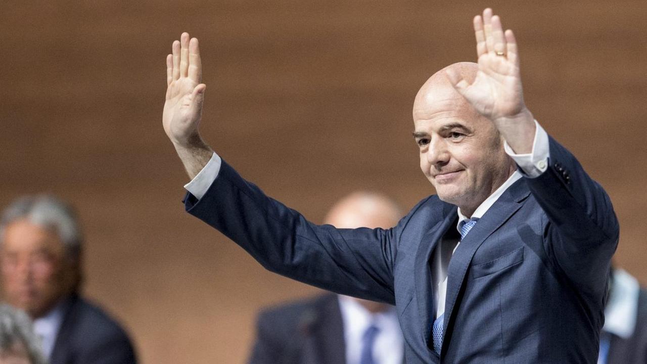 Gianni Infantino blickt vom Podium des FIFA-Kongresses in die Runde der Delegierten und hebt zum Dank für seine Wahl die Arme.