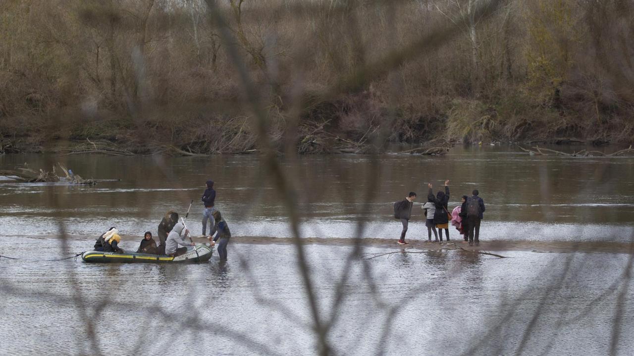 Migranten haben in einem Schlauchboot den Fluss Meric zwischen der Türkei und Griechenland überquert und gehen gerade an Land.