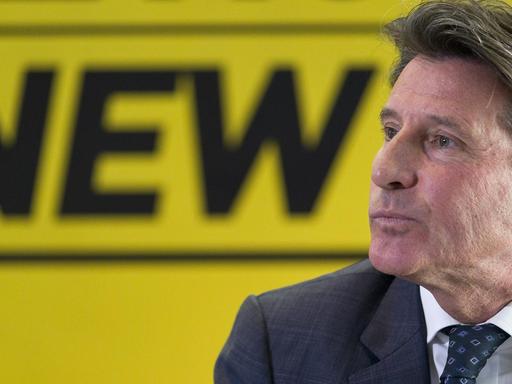 Sebastian Coe im Profil, vor einer gelben Wand, auf der das Wort "New" geschrieben steht.