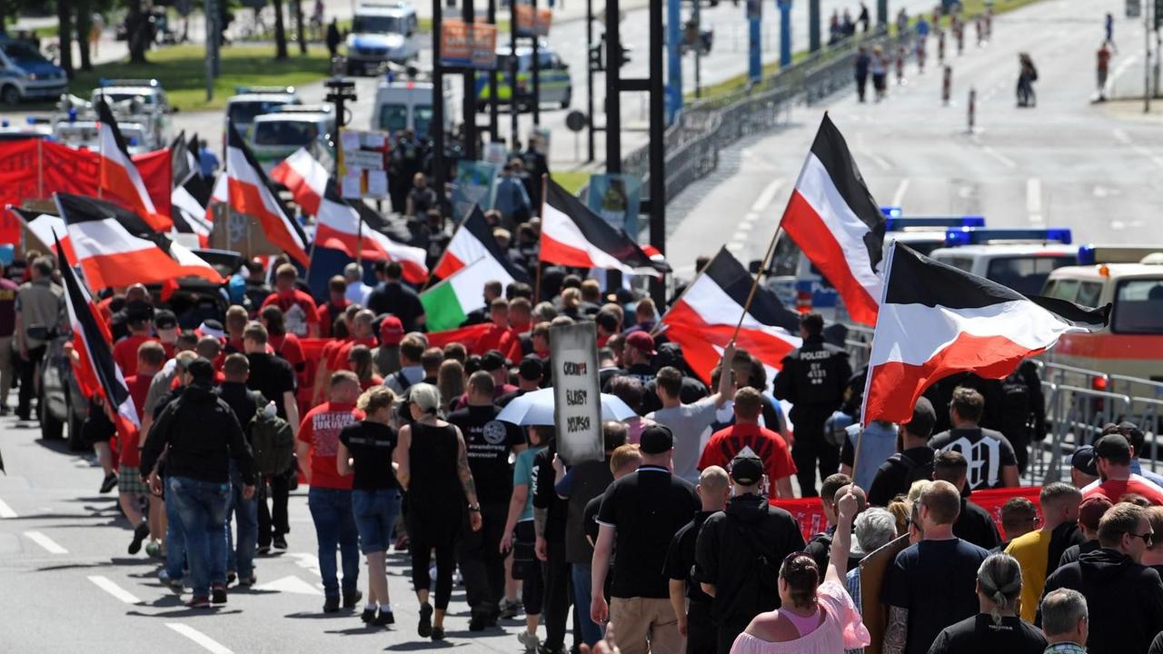 Teilnehmer einer Demonstration der rechtsextremen NPD-Nachwuchsorganisation Junge Nationaldemokraten ziehen mit schwarz-weiß-roten Flaggen durch Chemnitz.