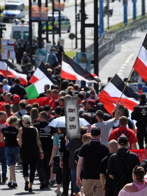 Teilnehmer einer Demonstration der rechtsextremen NPD-Nachwuchsorganisation Junge Nationaldemokraten ziehen mit schwarz-weiß-roten Flaggen durch Chemnitz.