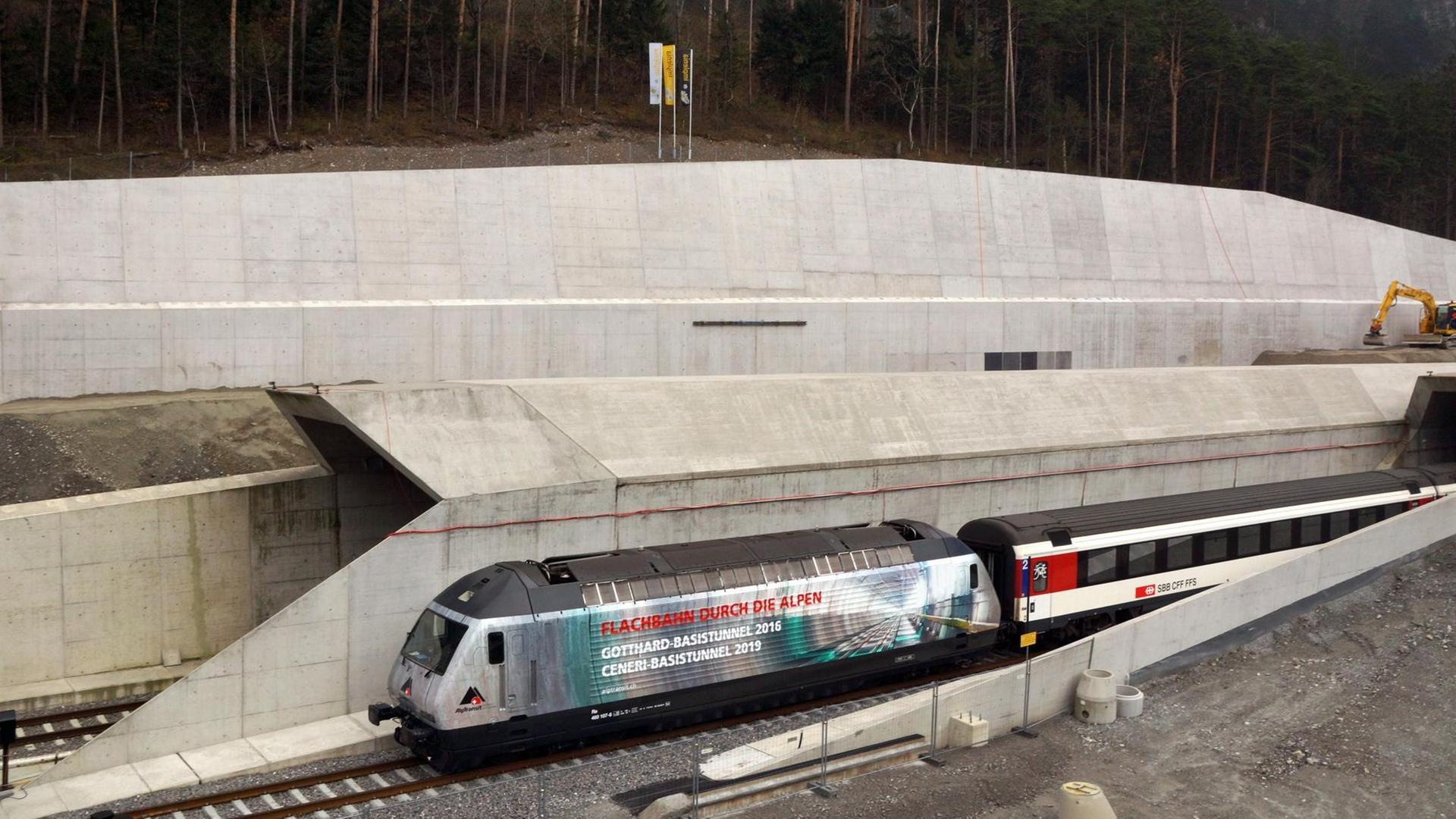 Eine Lok mit der Aufschrift "Flachbahn durch die Alpen Gotthard-Basistunnel 2016 Ceneri-Basistunnel 2016" fährt am 15.11.2012 bei Erstfeld bei der Loktaufe aus dem Gotthard-Basistunnel.