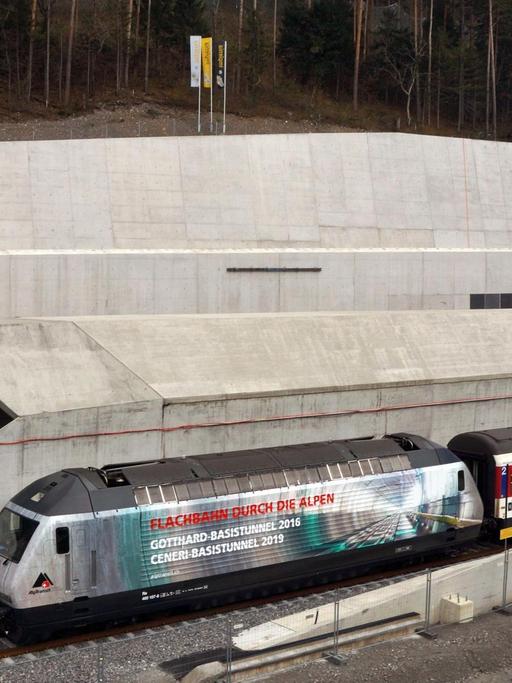 Eine Lok mit der Aufschrift "Flachbahn durch die Alpen Gotthard-Basistunnel 2016 Ceneri-Basistunnel 2016" fährt am 15.11.2012 bei Erstfeld bei der Loktaufe aus dem Gotthard-Basistunnel.