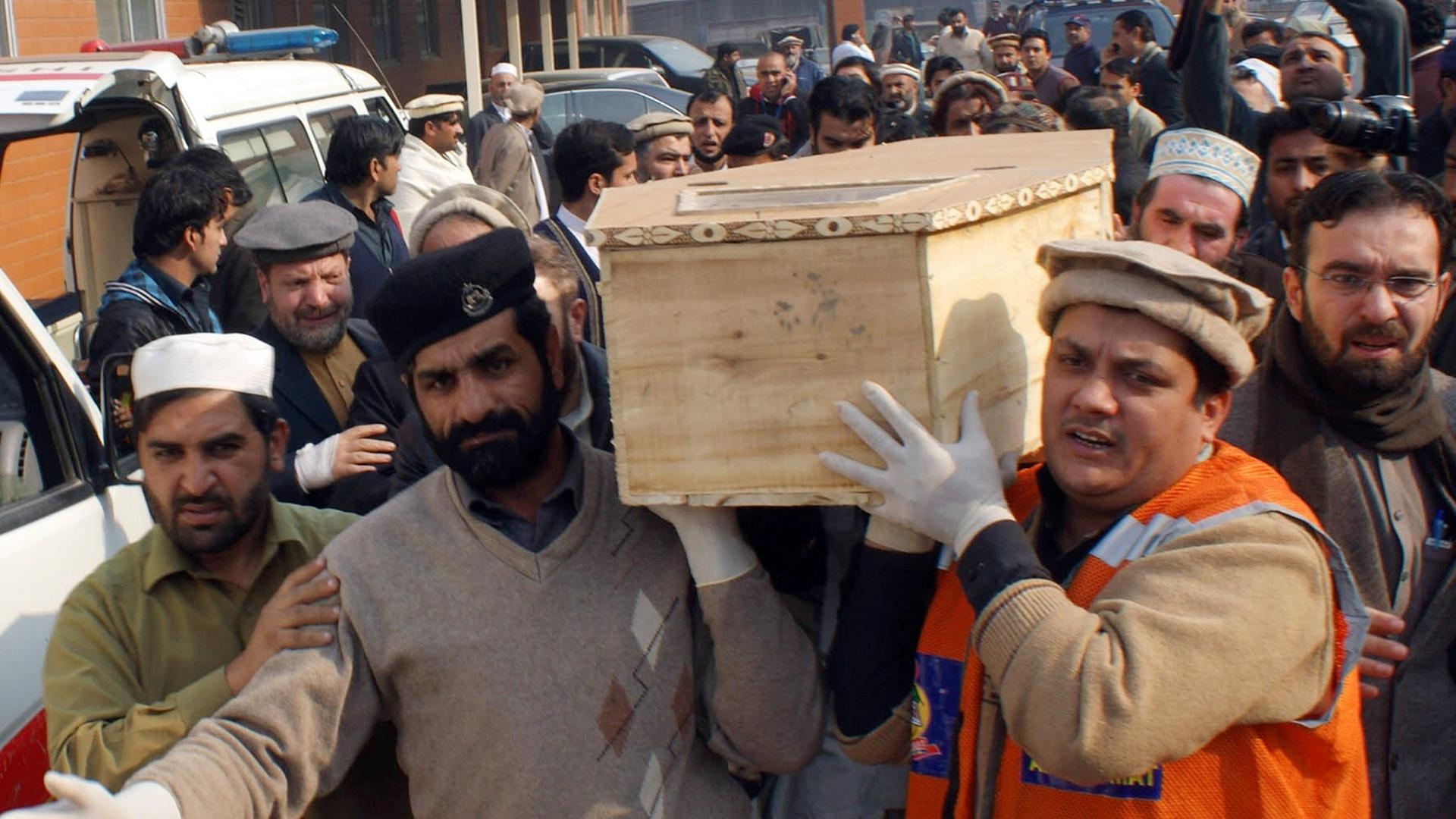 Freiwillige tragen einen Sarg nach dem Taliban-Angriff auf eine Schule in Pakistan.
