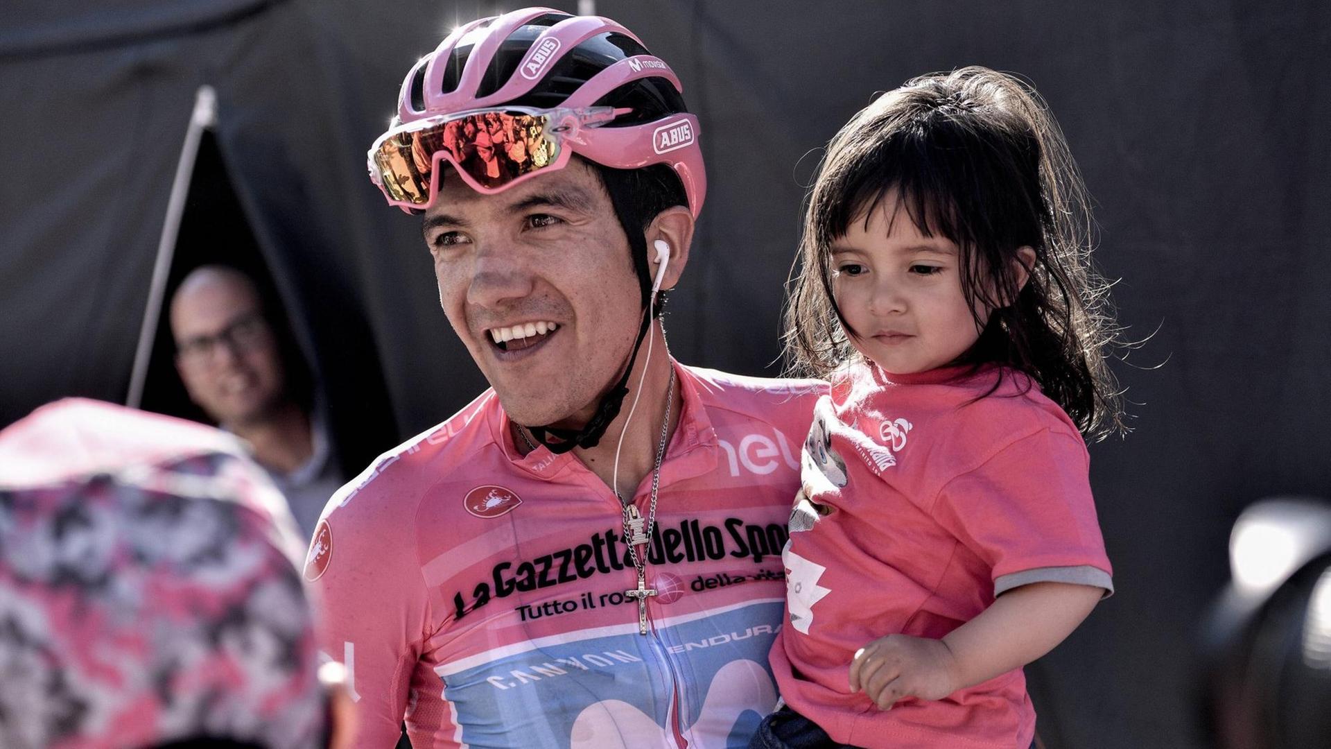 Richard Carapaz, diesjähriger Favorit beim Giro d'Italia, mit einem kleinen Mädchen auf dem Arm