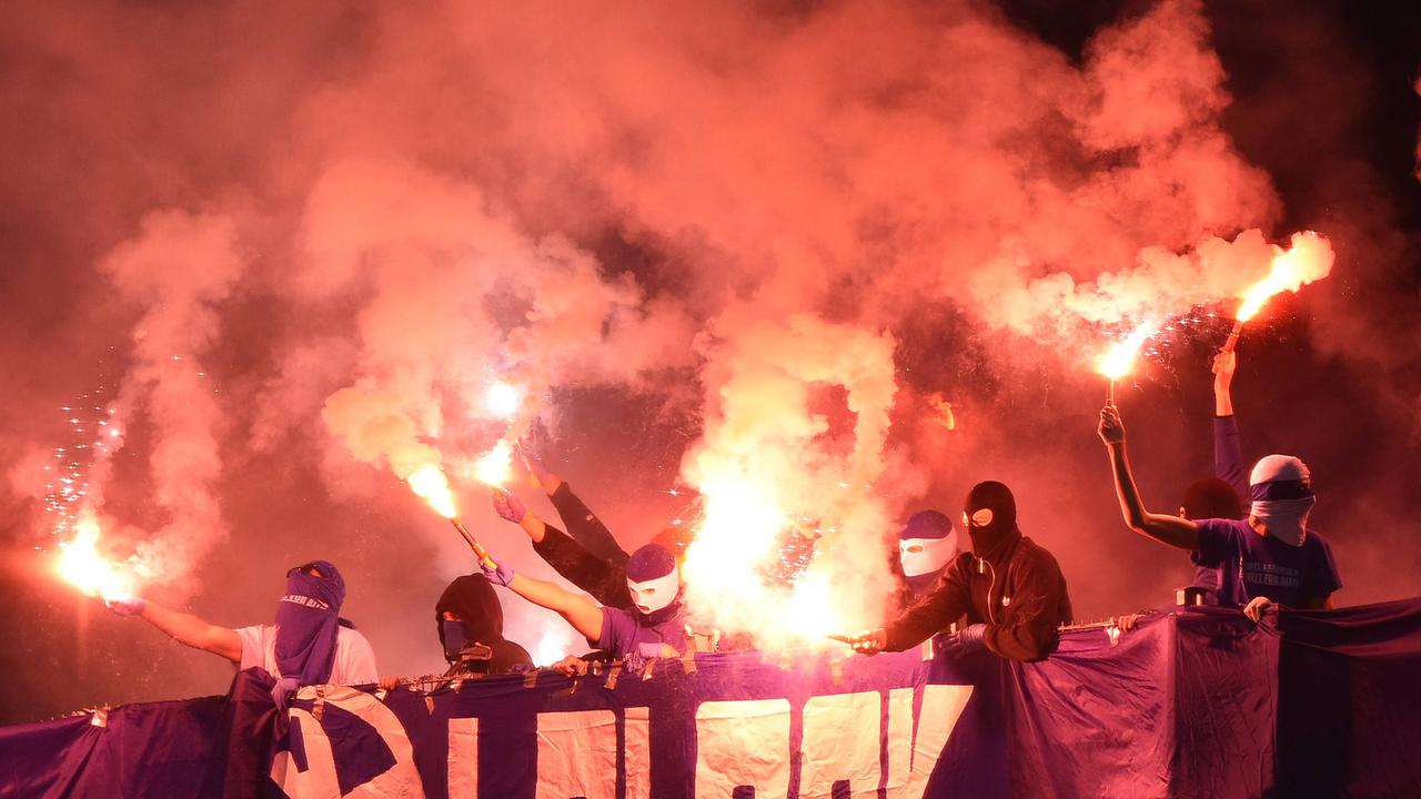 Bengalos und Pyrotechnik von vermummten Hooligans im Fanblock in der Mercedes-Benz Arena in Stuttgart