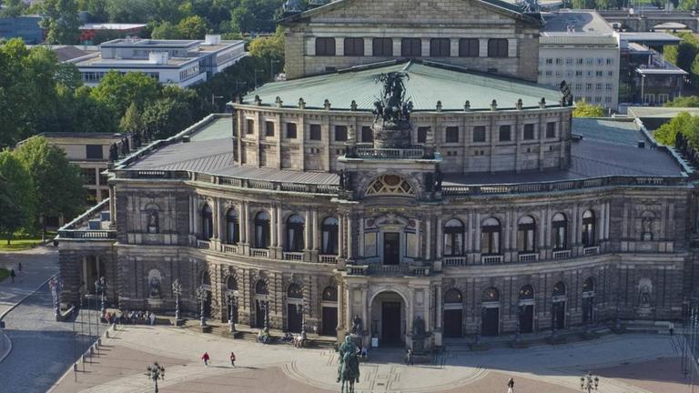 Luftbild der Semperoper, die hinter einem großzügigen runden Platz liegt. Im Hintergrund die Elbe