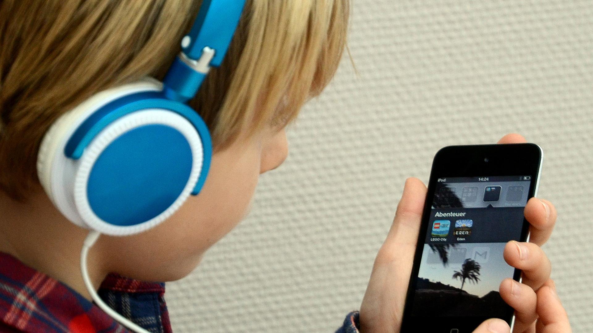 Ein Kind hört Musik mit seinem iPod von Apple.