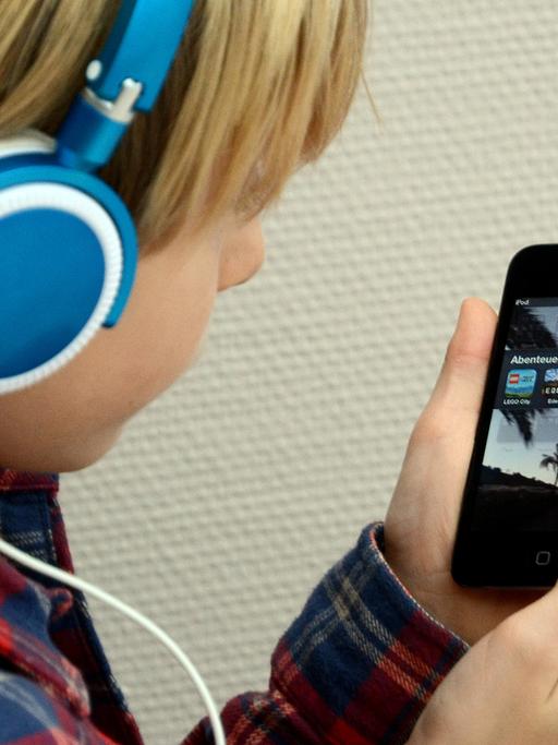 Ein Kind hört Musik mit seinem iPod von Apple.