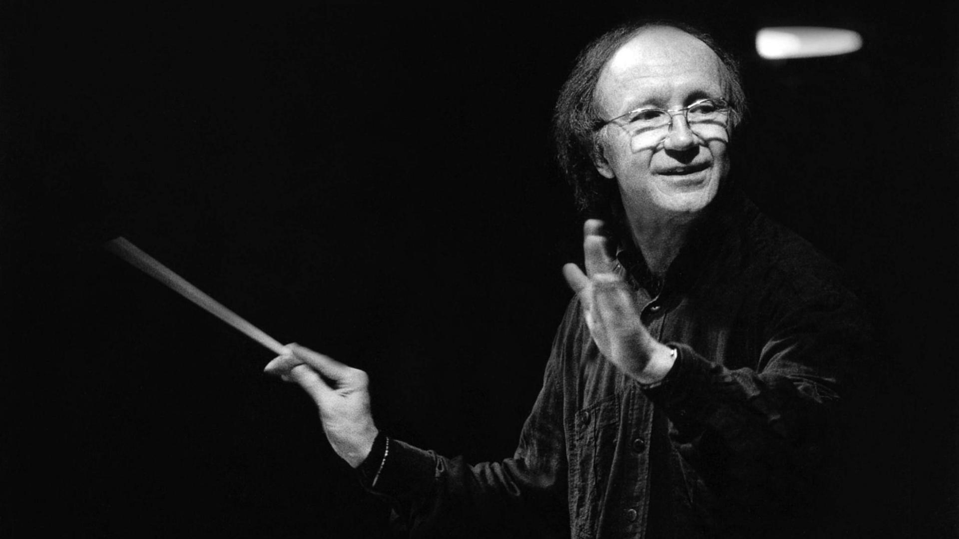 Heinz Holliger dirigiert 1996 mit Taktstock in einem schwarzen Hemd die Münchner Philharmoniker in der Philharmonie München, Schwarz-Weiß-Aufnahme