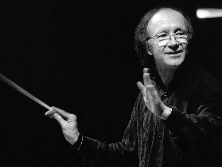 Heinz Holliger dirigiert 1996 mit Taktstock in einem schwarzen Hemd die Münchner Philharmoniker in der Philharmonie München, Schwarz-Weiß-Aufnahme