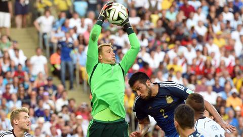 Manuel Neuer springt mit angestrengter Miene in die Luft und fängt einen Ball im Finale der WM gegen Argentinien.