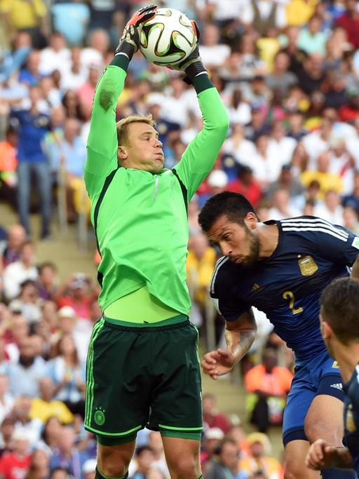 Manuel Neuer springt mit angestrengter Miene in die Luft und fängt einen Ball im Finale der WM gegen Argentinien.