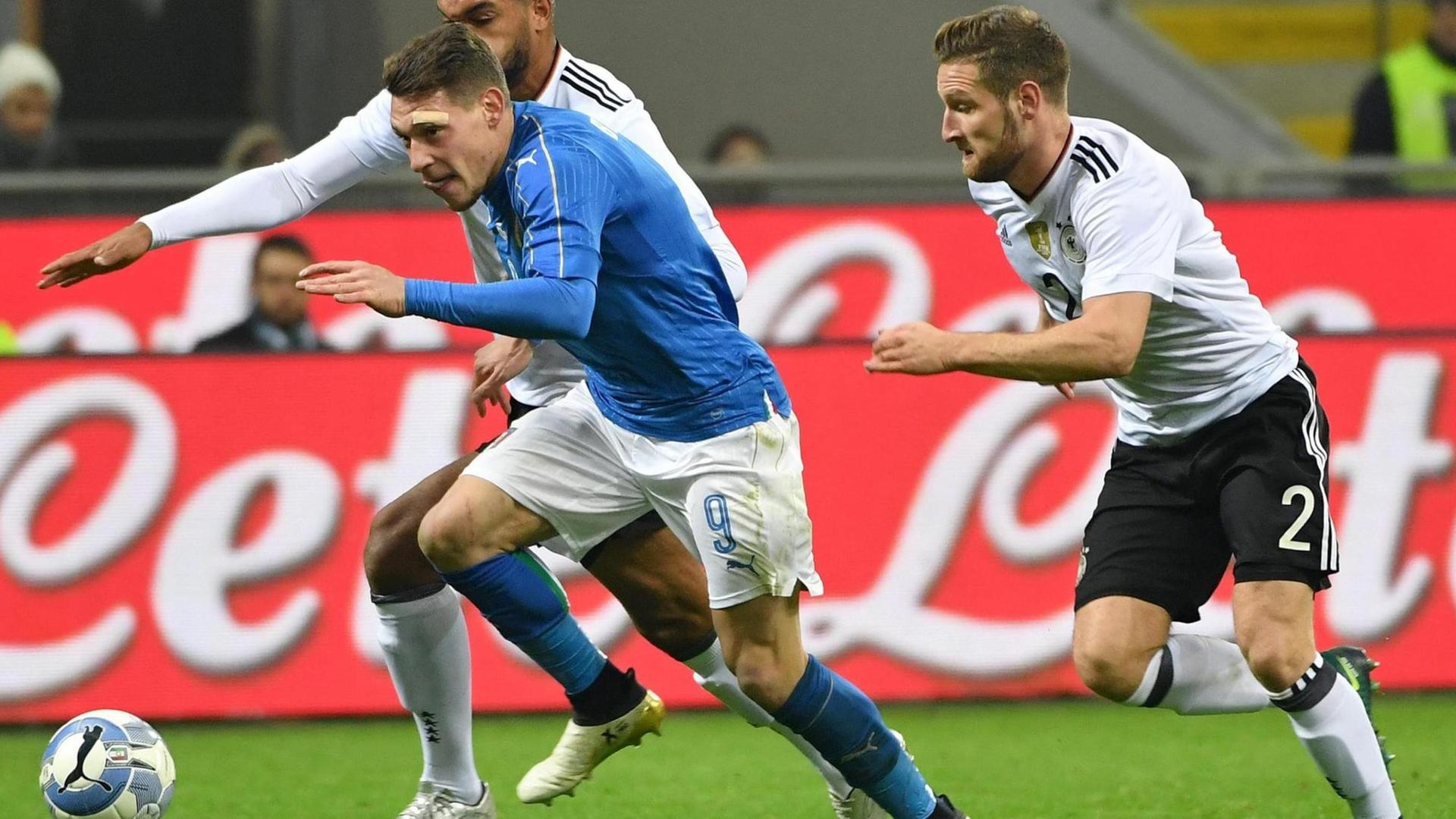 Sie sehen die Spieler Andrea Belotti aus Italien und die deutschen Spieler Shkodran Mustafi (rechts) und Jonathan Tah (links).