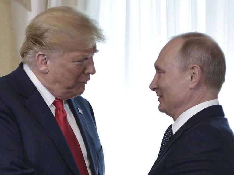 US Präsident Donald Trump (M) und der russische Präsident Wladimir Putin (r) am 16.7.2018 vor ihrem Treffen. 