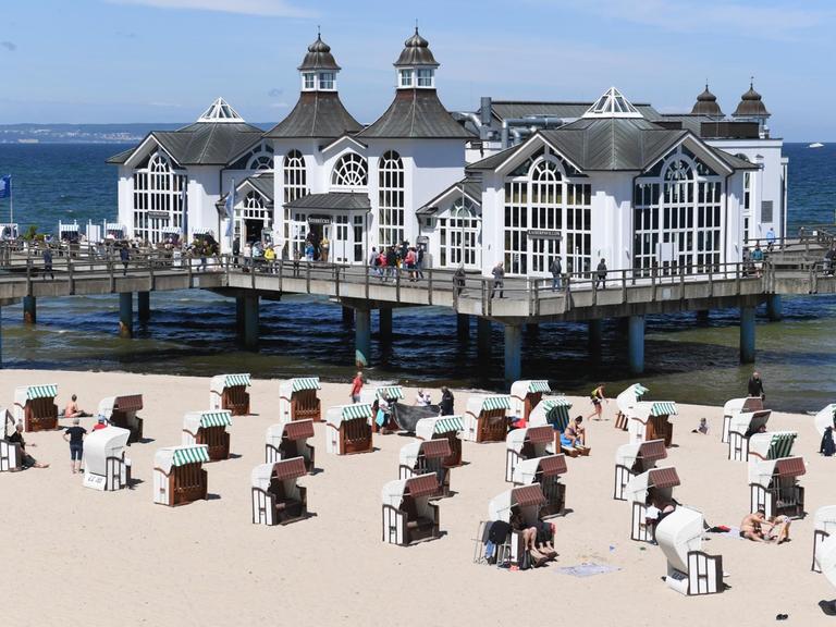 Am Ostseestrand von Sellin auf Rügen haben sich Badegäste in den Strandkörben niedergelassen. Tagestouristen dürfen allerdings weiter nicht nach Mecklenburg-Vorpommern reisen.