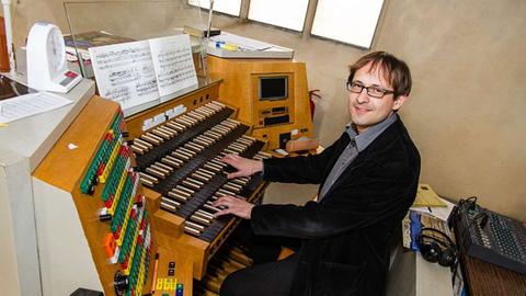Der Organist Dominik Susteck sitzt an der Orgel der Kunststation St. Peter in Köln
