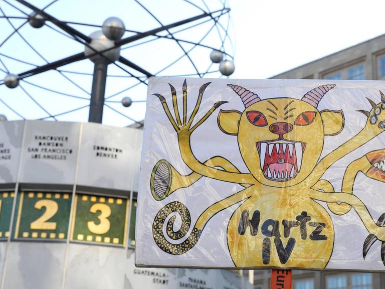 Ein Demonstrationsschild zeigt "Hartz IV" als Monster.