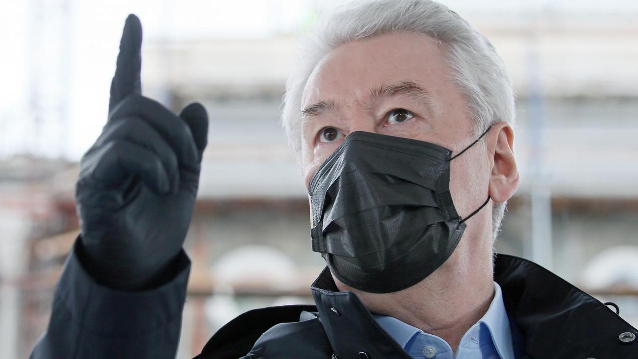 Sergej Sobjanin mit Atemschutzmaske besucht eine Baustelle in Moskau.