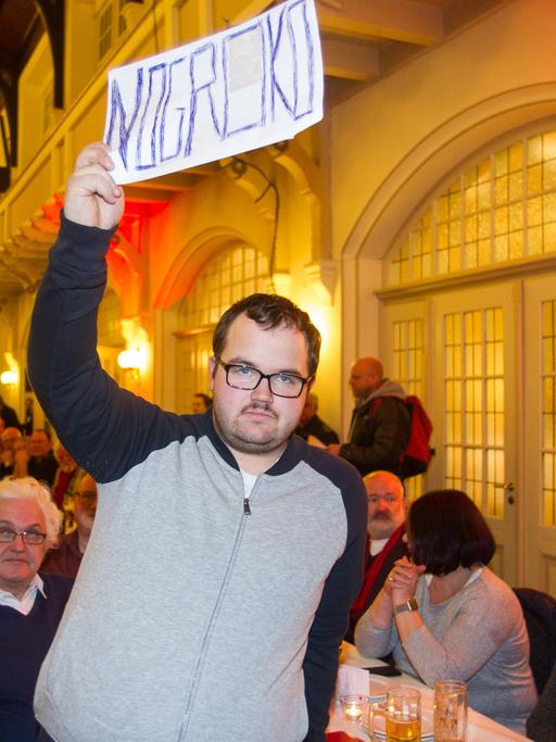 Beim politischen Aschermittwoch der SPD in Schwerte am 14.02.2018 hält ein Mann ein NoGroKo-Schild hoch.