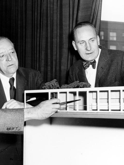 Der Architekt Ludwig Mies van der Rohe (M) mit Herbert S. Greenwald (l) und Robert H. McCormick jr. (r) vor dem Modell eines von ihm entworfenen und in Chicago gebauten Hauses aus Glas und Stahl (undatiert).