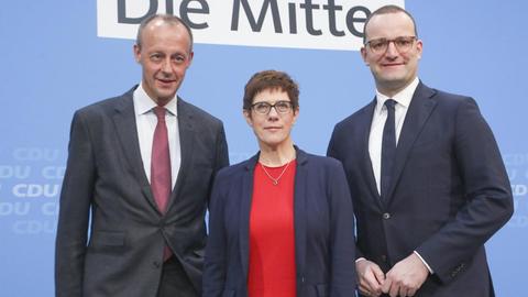 Friedrich Merz , Annegret Kramp-Karrenbauer und Jens Spahn stehen vor einer blauen Wand.